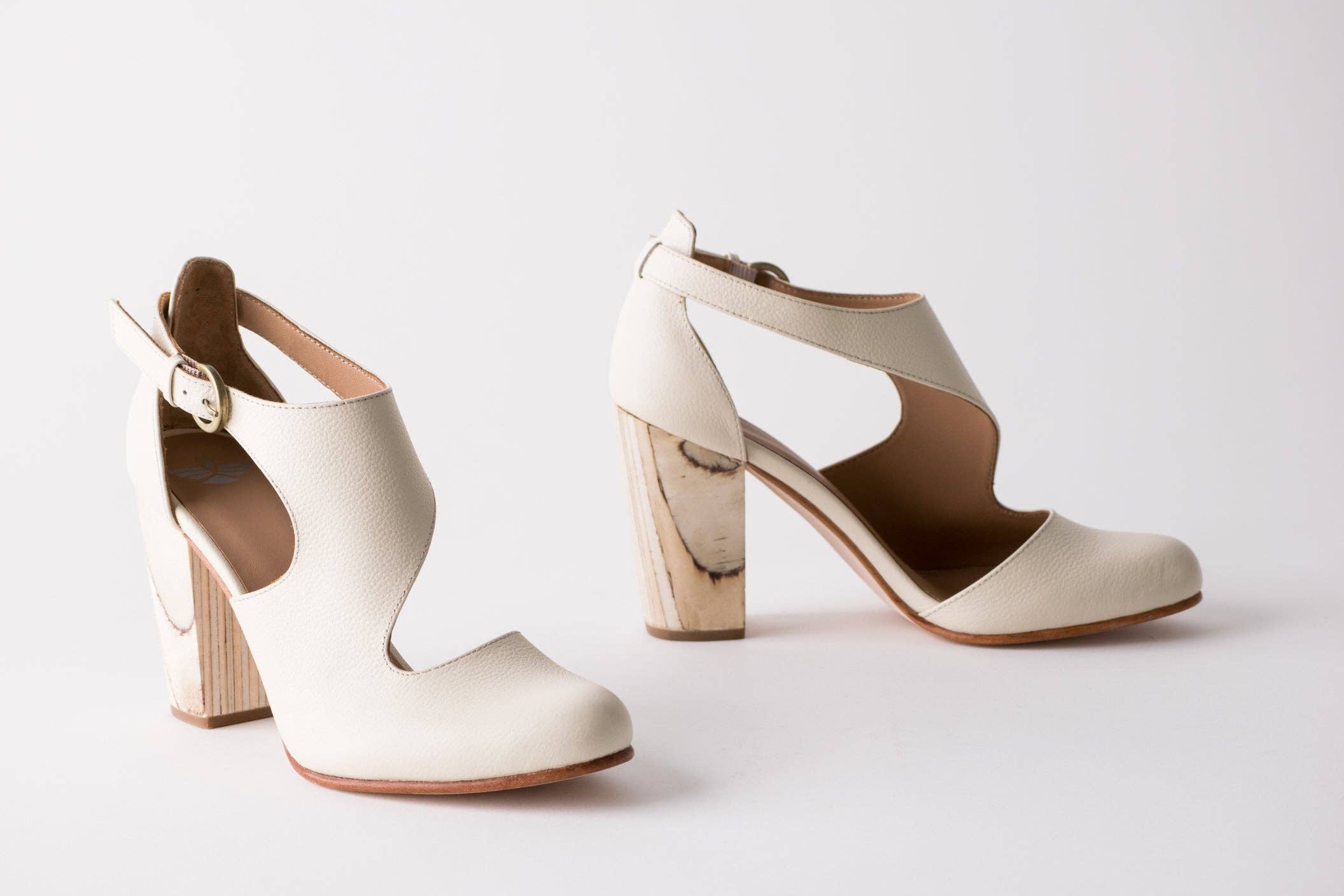 Pair of cream high-heeled shoes on a light gray background