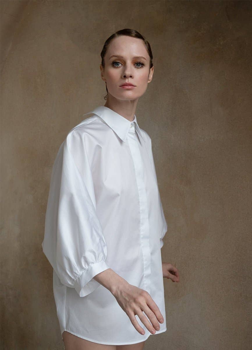 Woman wearing a white shirt against a brown background