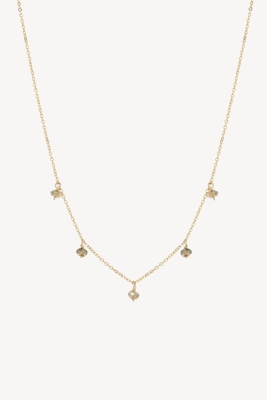 A gold-filled necklace with five tiny greyish/green labradorite stones on a thin chain.