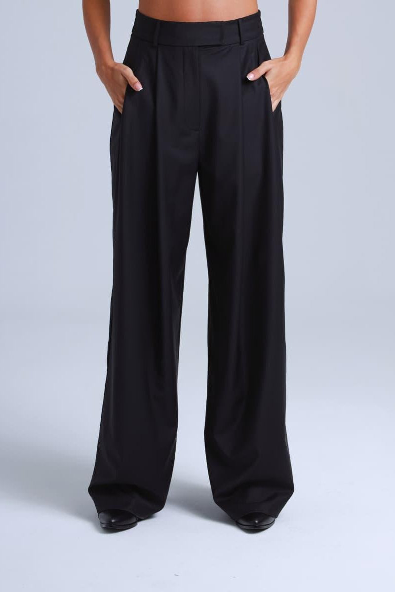Black wide-leg pants worn by a person on a light gray background