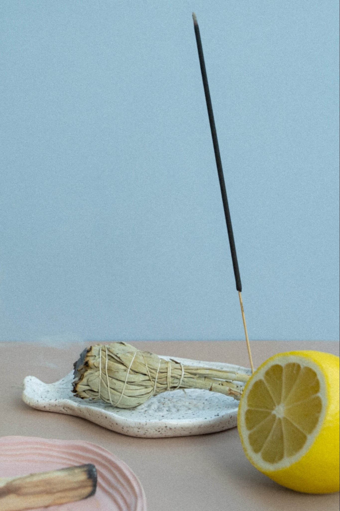 Incense stick with lemons and a bundle of sticks on a light blue background