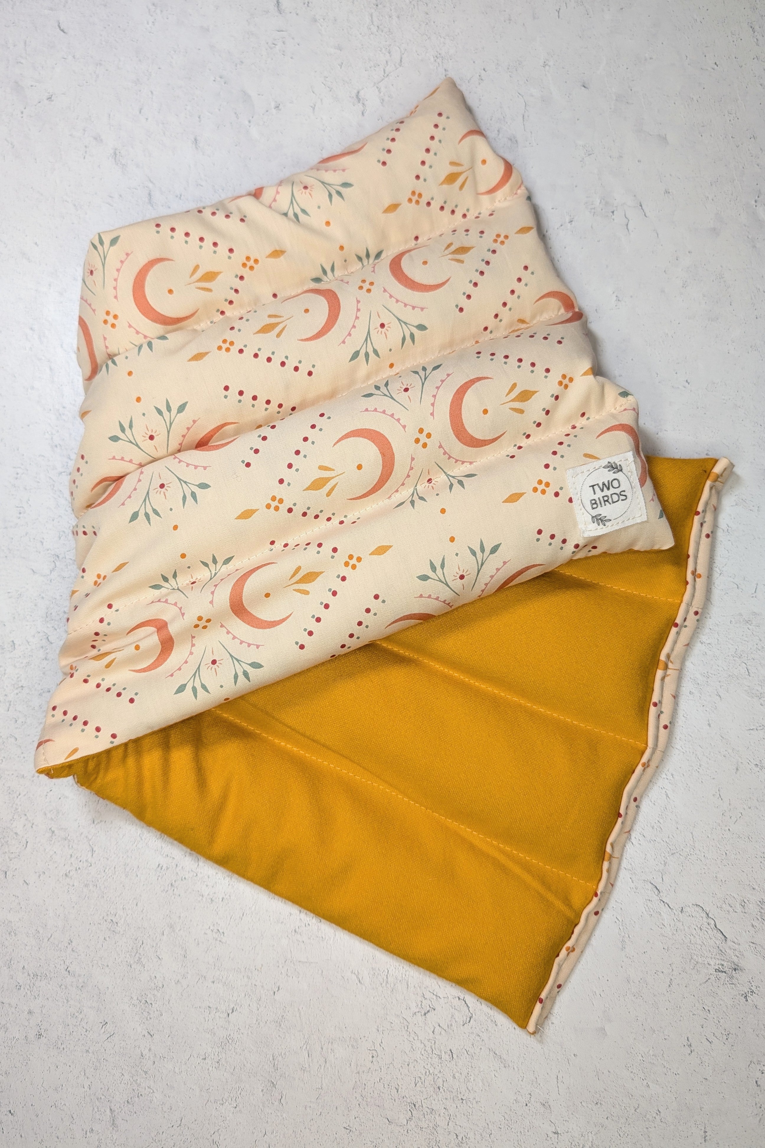 Folded fabric with moon and star pattern on a textured surface