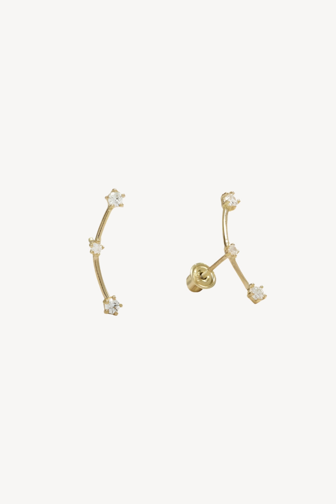 Pair of gold earrings with small crystal studs that resemble the orion's belt constellation.