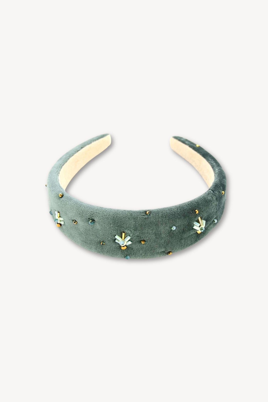 Green headband with decorative elements on a white background