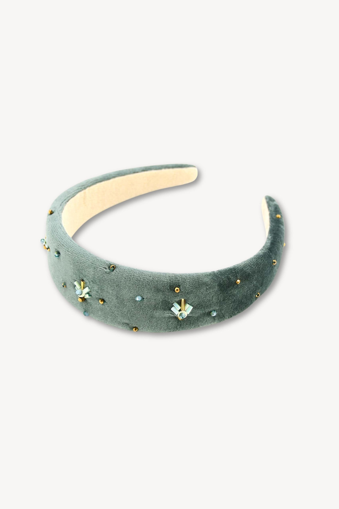Green velvet headband with floral embellishments on a white background