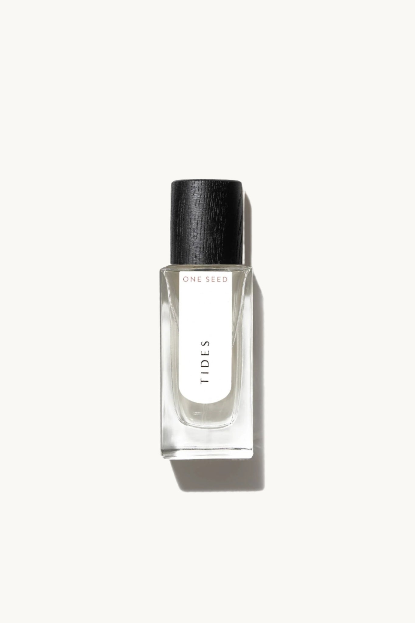 Small glass fragrance bottle with black cap labeled 'TIDES' on a white background