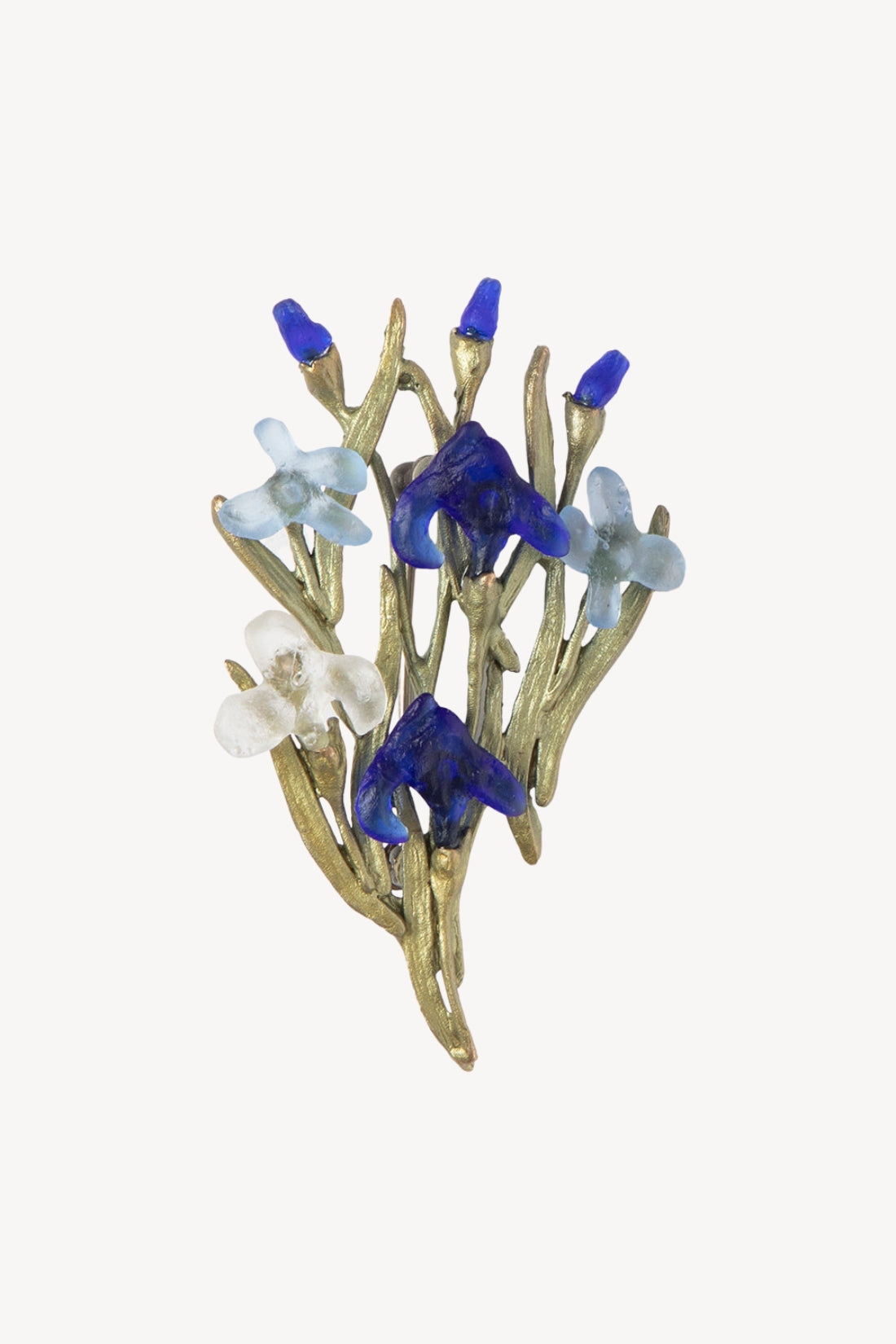 A vintage-style floral brooch featuring gold-tone branches with cobalt blue and light blue flower petals, reminiscent of Vincent Van Gogh's Irises painting, set against a plain off-white background.