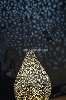 Decorative lamp with intricate design casting shadows on a wall