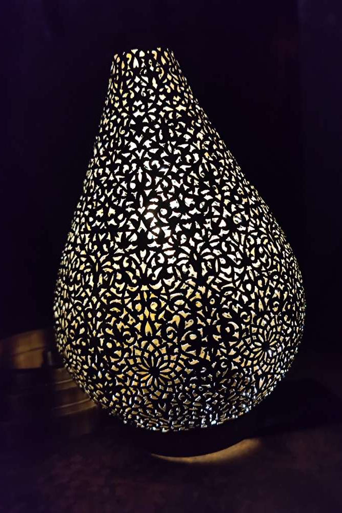 Decorative lamp with intricate cut-out pattern on a dark background