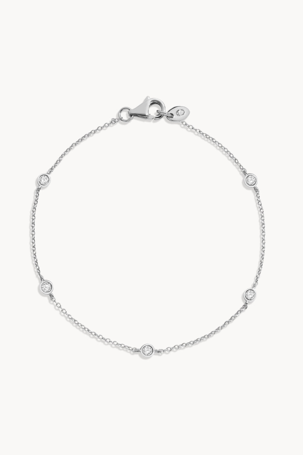 Silver bracelet with bezeled white sapphires against a white background.
