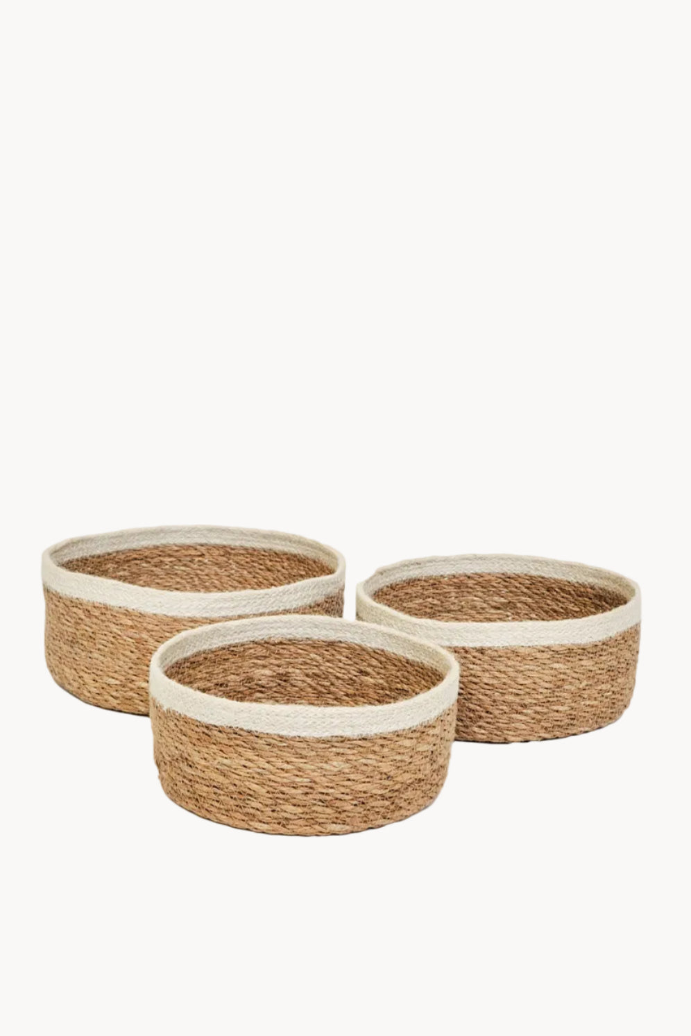 Three woven baskets with natural and white trim on a white background
