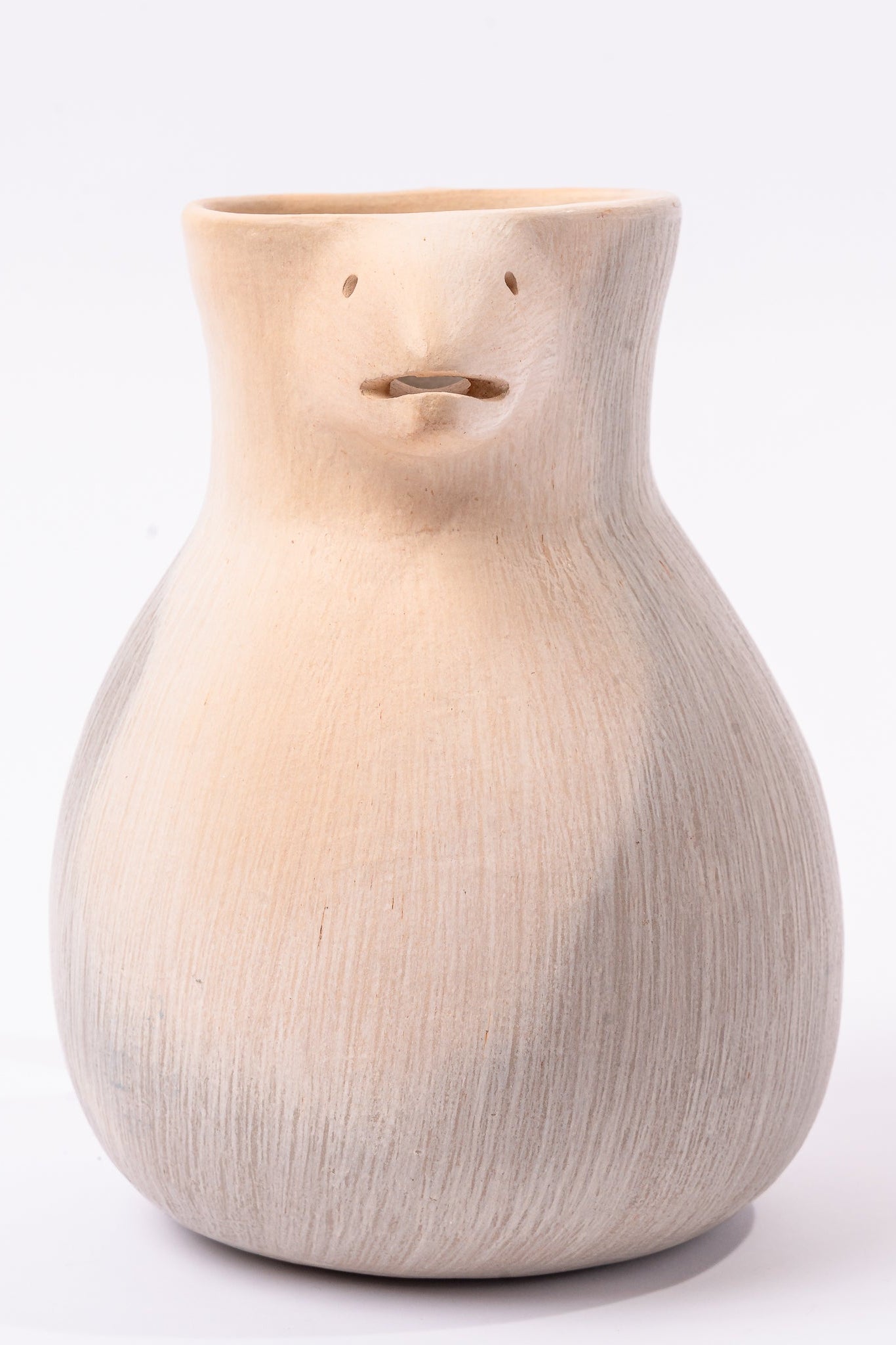 Ceramic vase with a face-like design on a white background