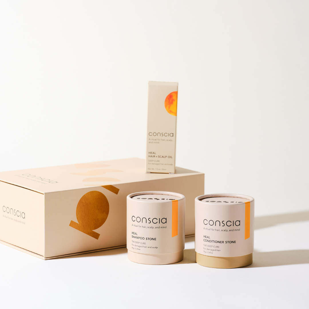 Conscia hair care products including bottles and a box on a white background