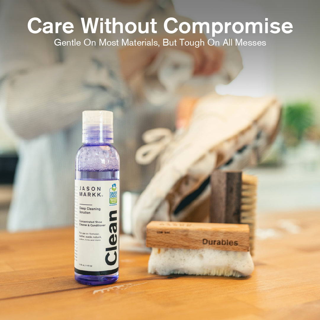 Bottle of Jason Markk Clean on a wooden surface with cleaning tools, text 'Care Without Compromise'.