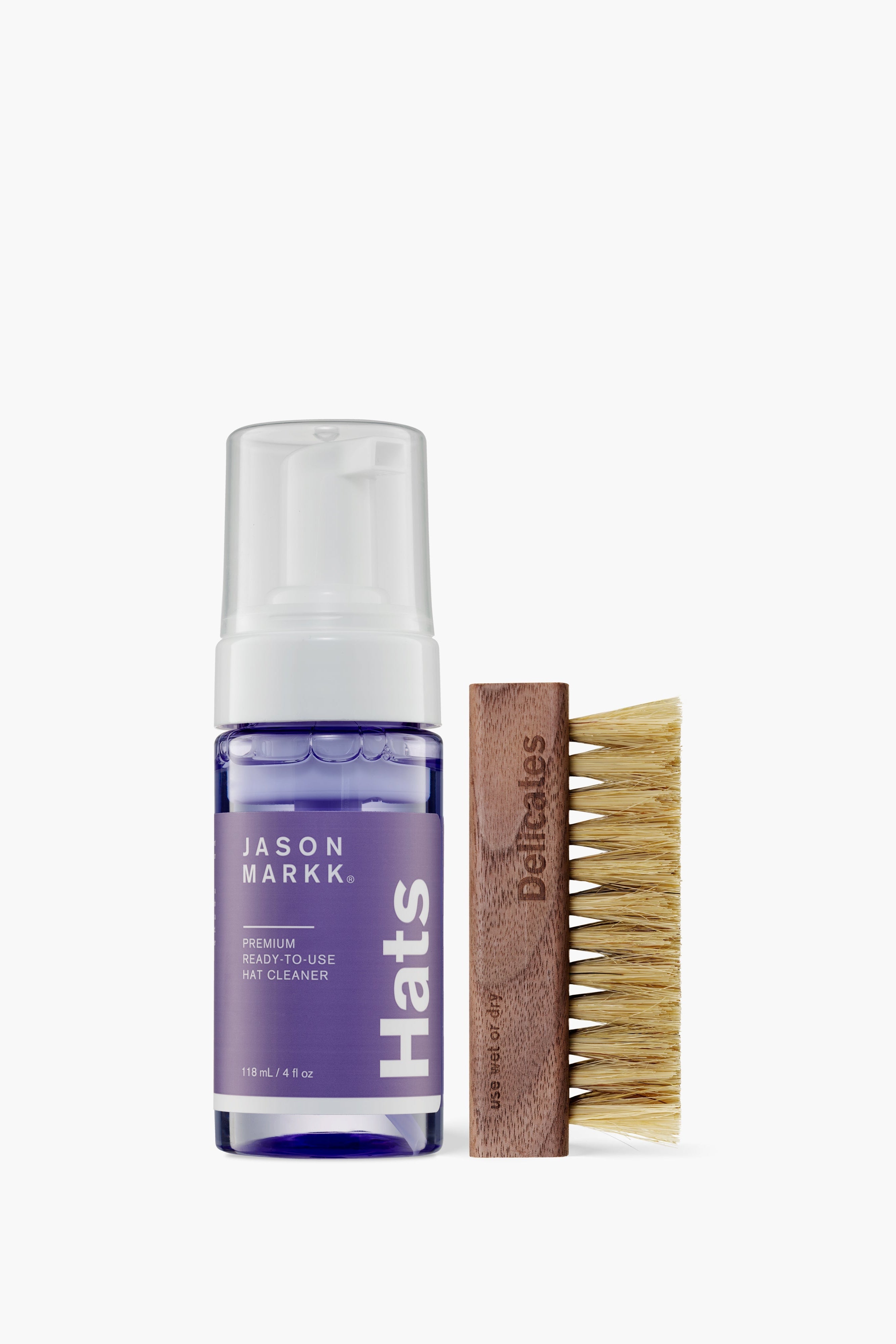 Bottle of Jason Markk shoe cleaner and a brush on a white background