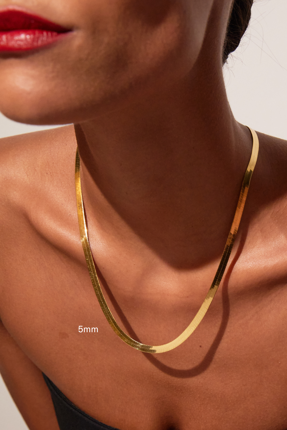 Gold necklace on a person's neck with a close-up view