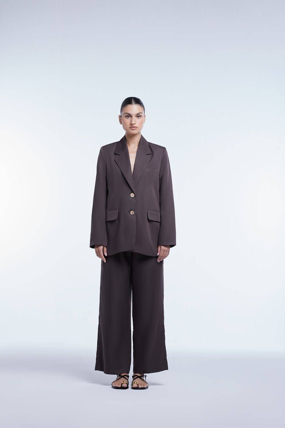 Woman wearing a brown suit on a white background