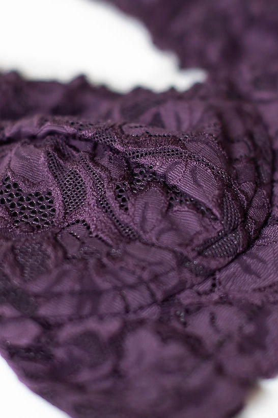 Close-up of purple lace fabric on a white background