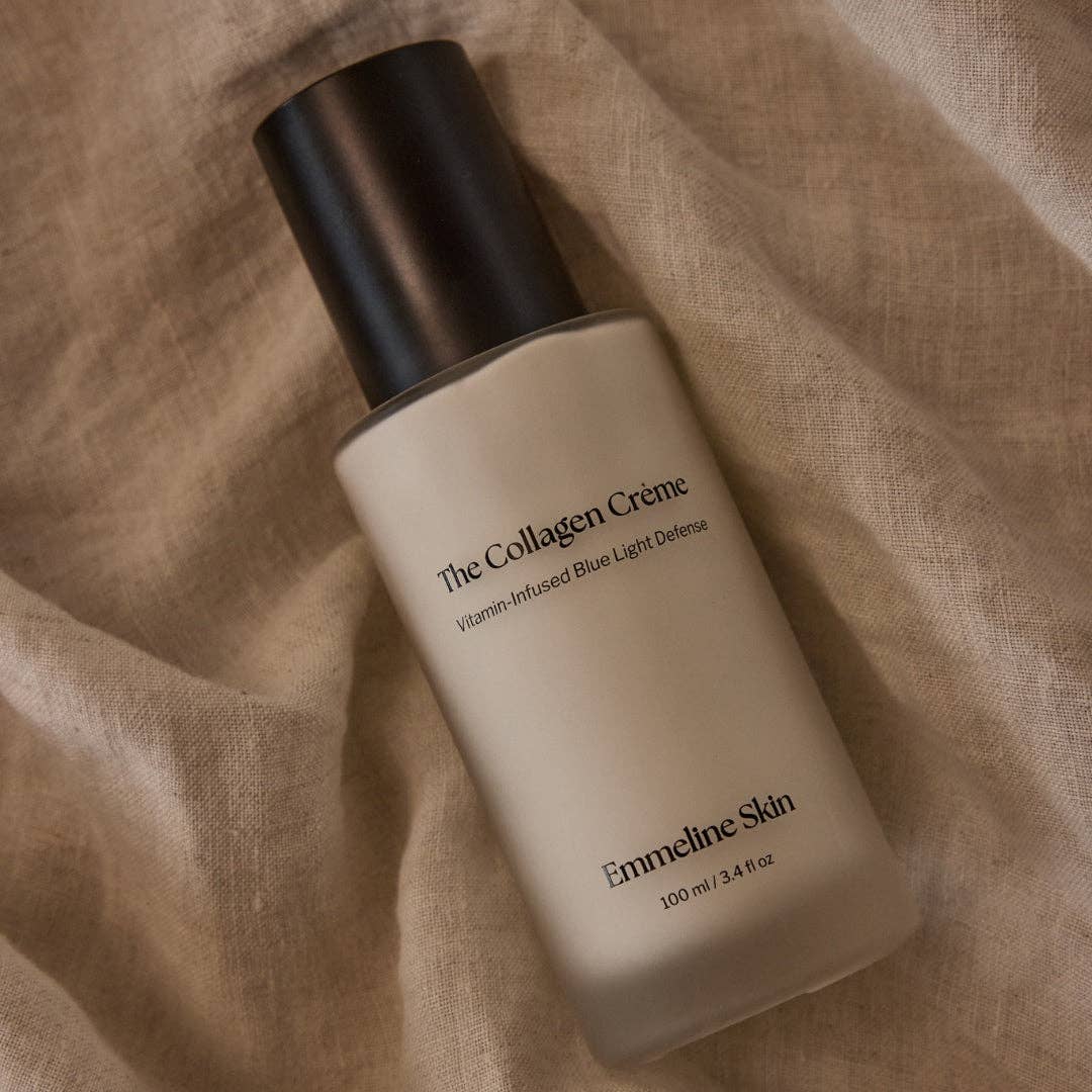 Cosmetic bottle labeled 'The Collagen Crème' by Emmeline Skin on a textured beige background