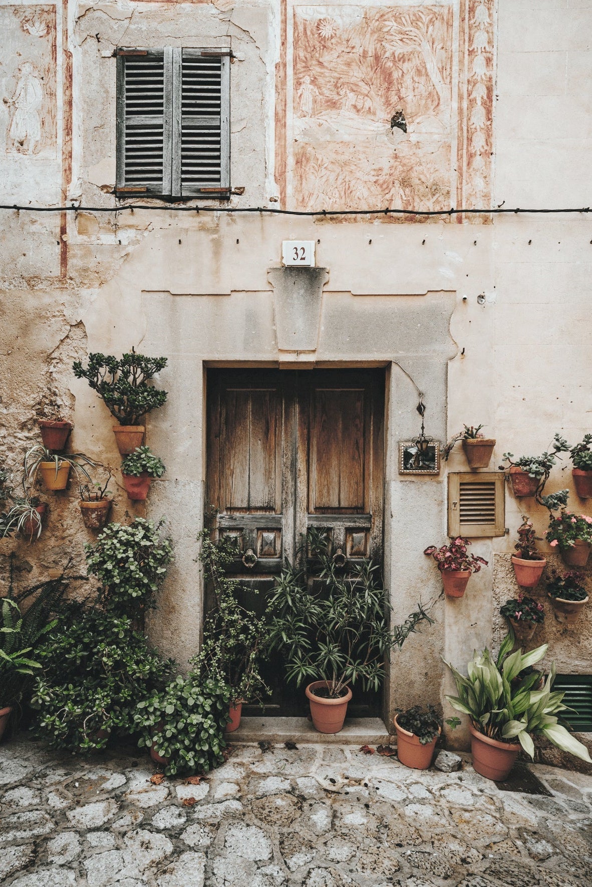 Decorative entrance with potted plants on a stone street