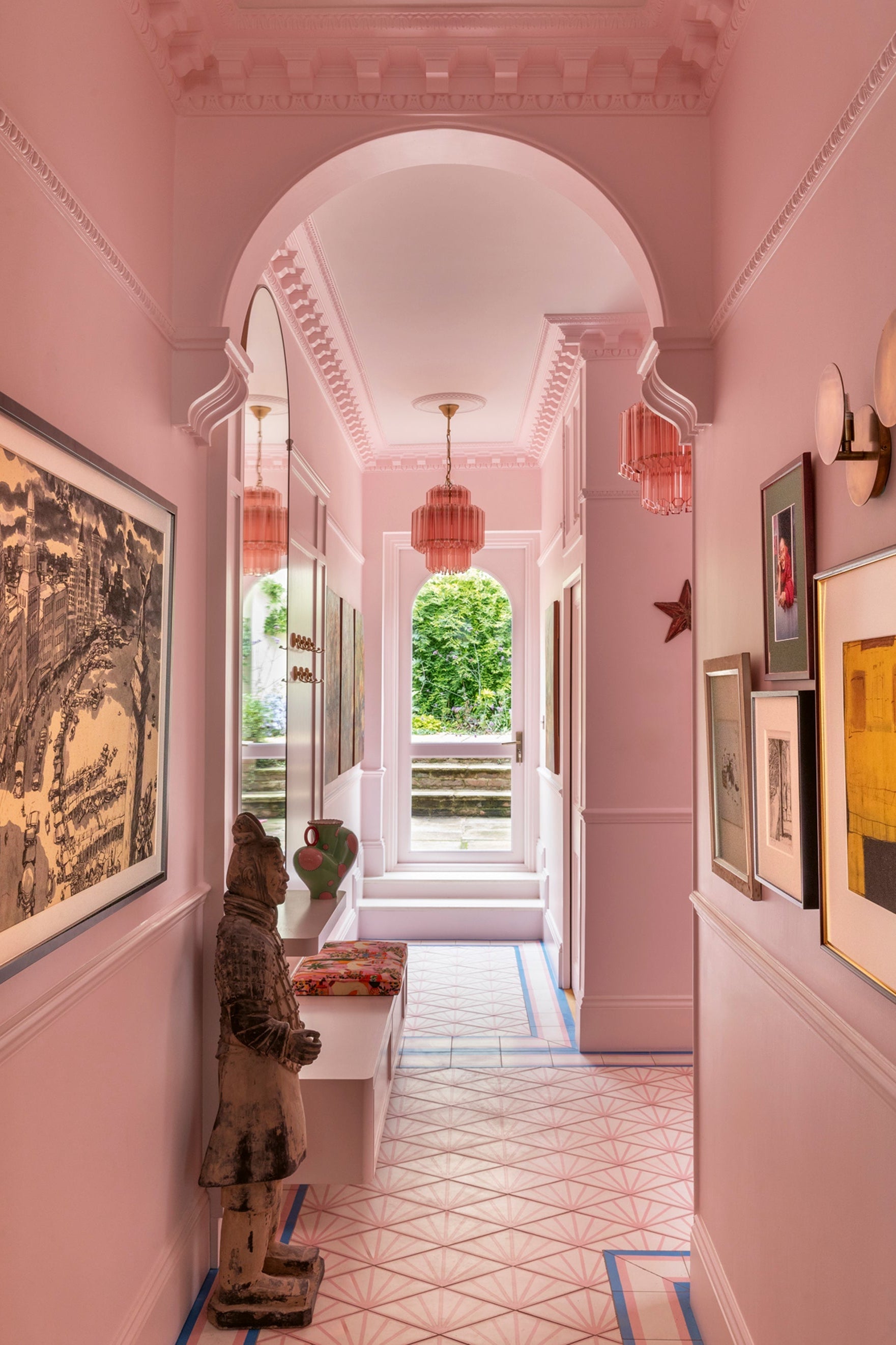 Pink hallway with decorative elements and framed pictures.
