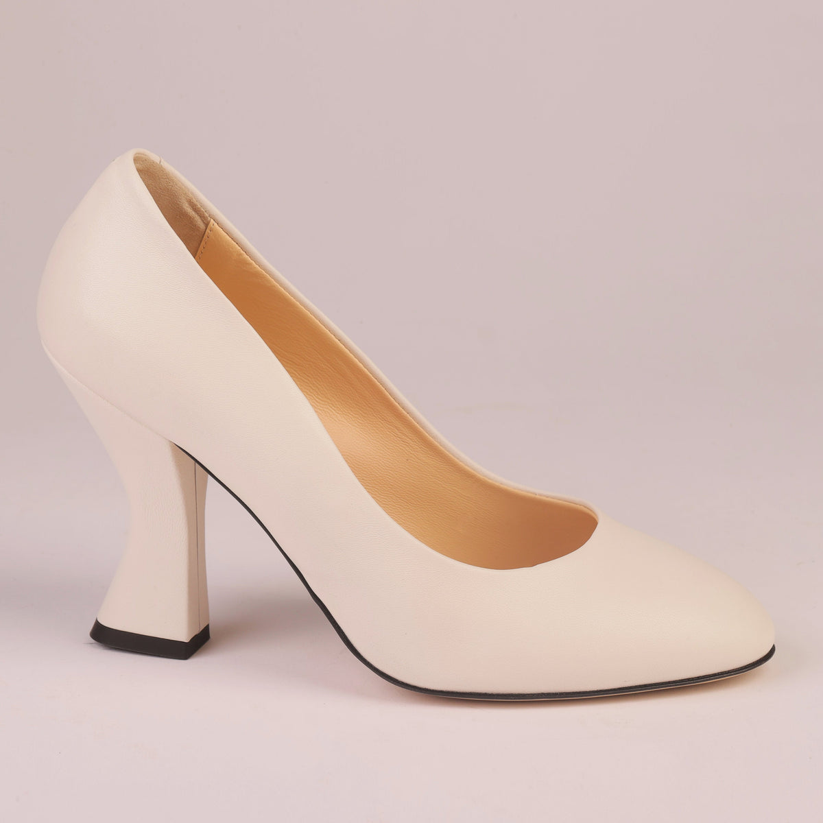 A single cream-colored leather high-heeled pump with a pointed toe and a chunky block heel, shown from a side profile on a solid light pink background.