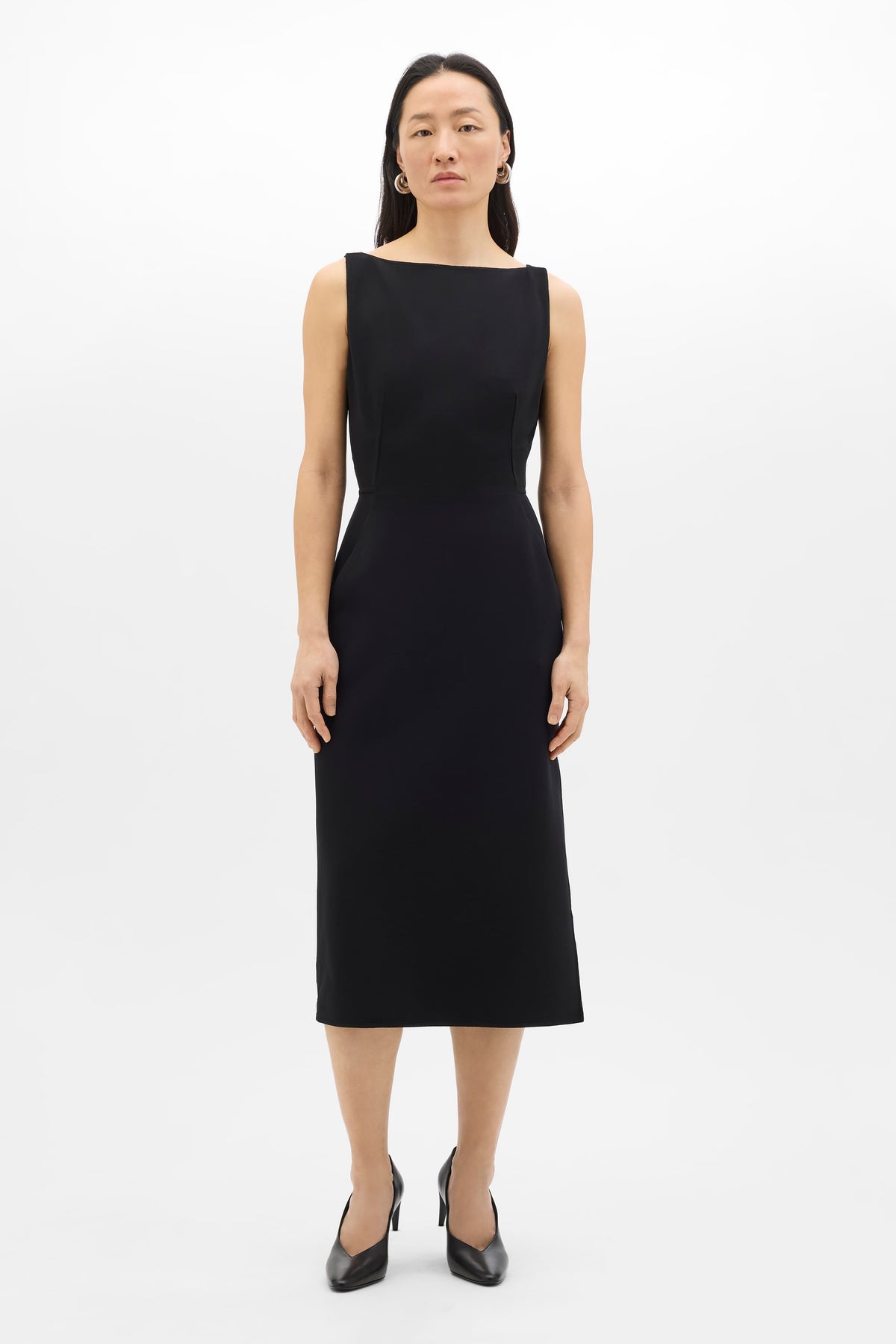Woman wearing a black sleeveless dress on a white background