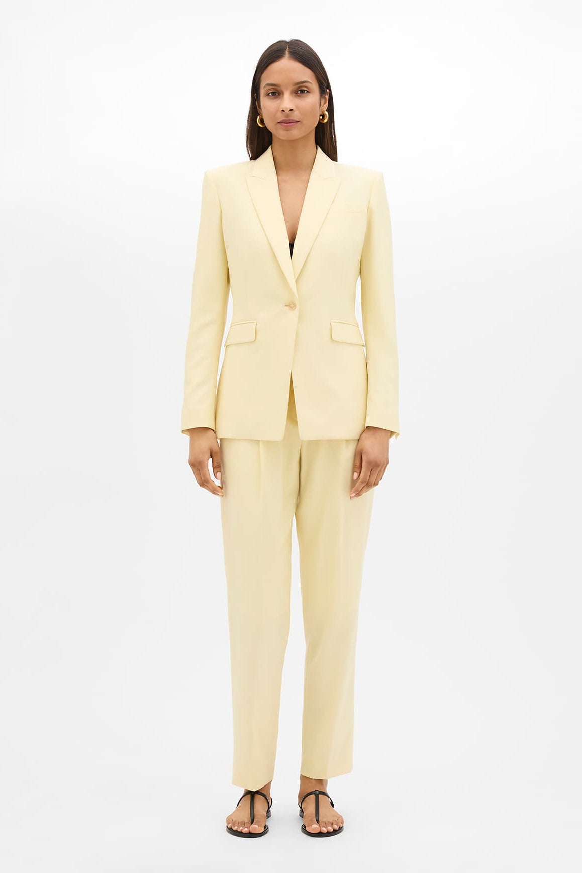 Woman wearing a light yellow suit on a white background
