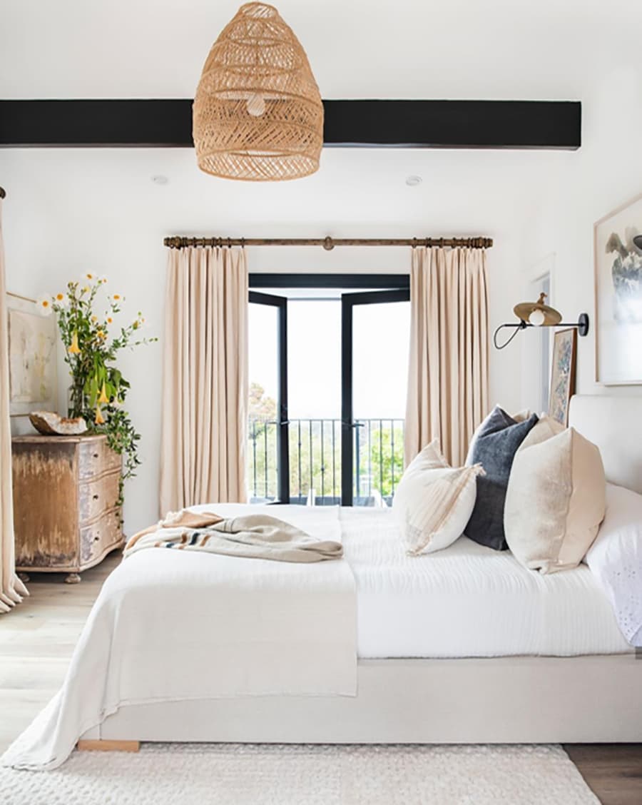 Modern bedroom with a bed, lamp, and decor elements.