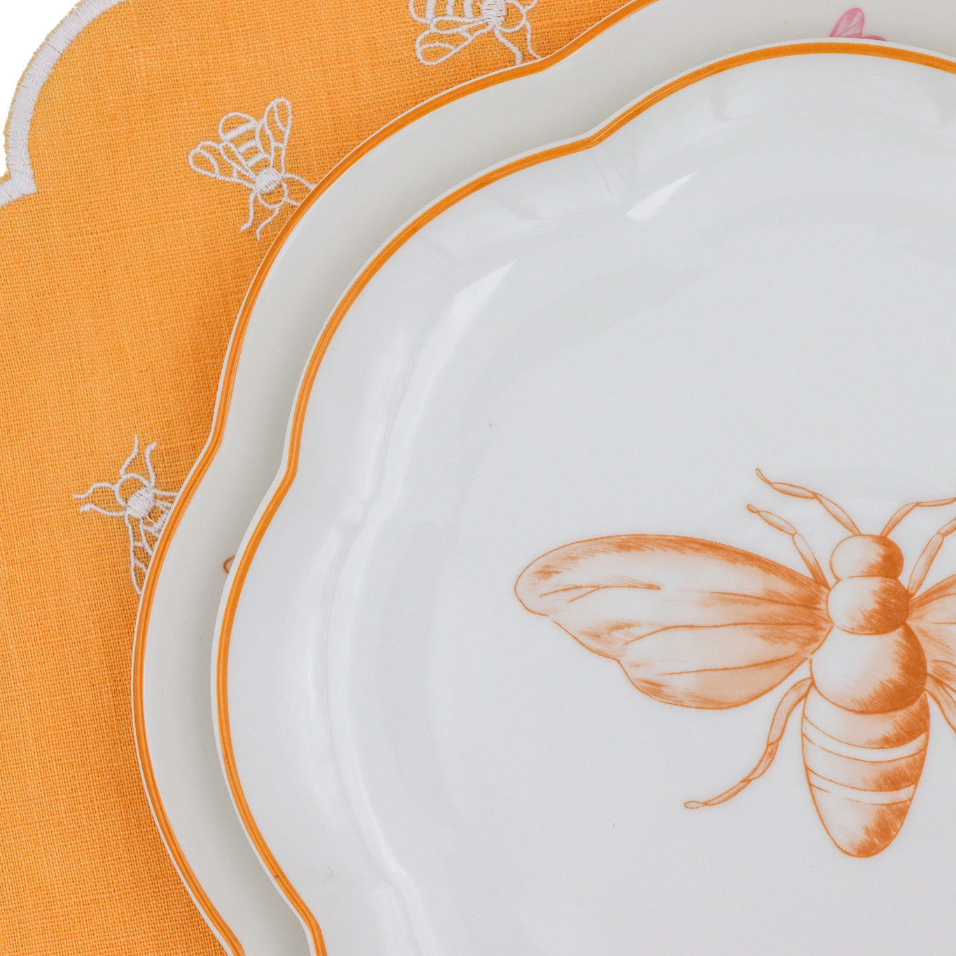 White plate with orange bee design on a matching placemat