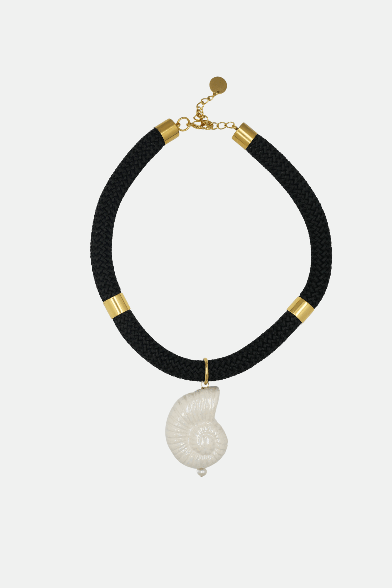 Black choker necklace with gold accents and a white shell pendant on a white background