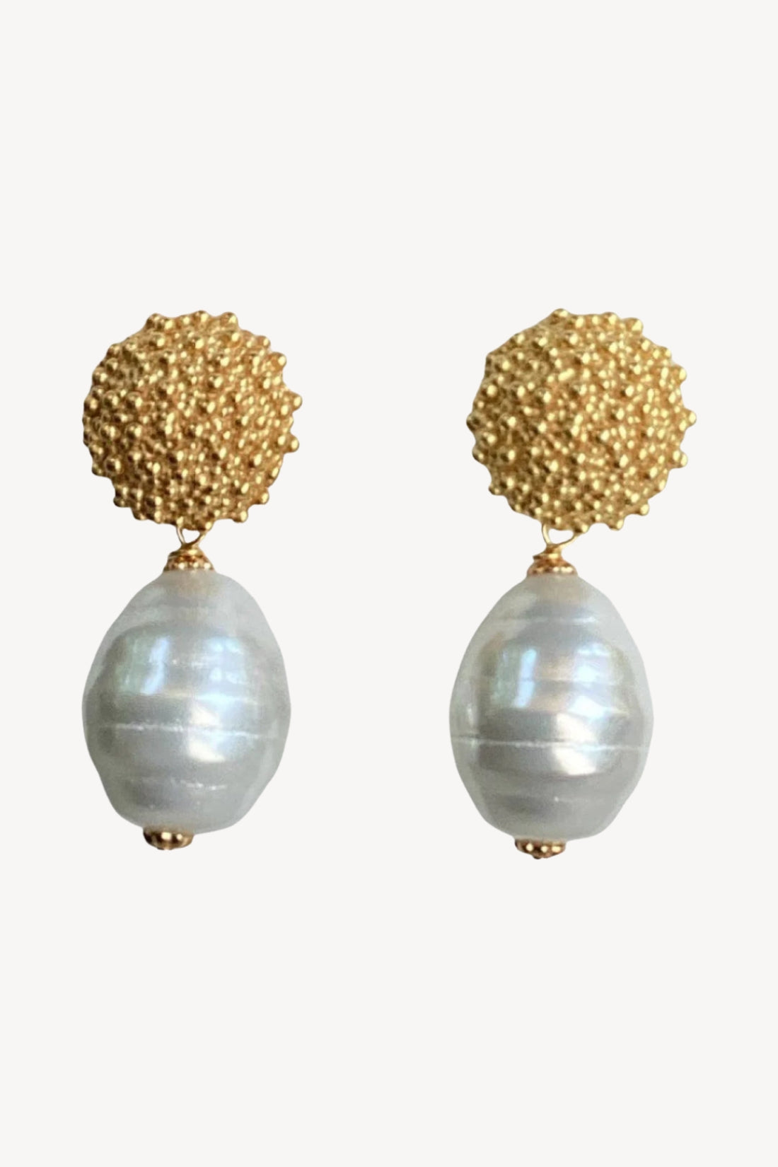 Pair of earrings with gold spherical tops and gray beads on a white background