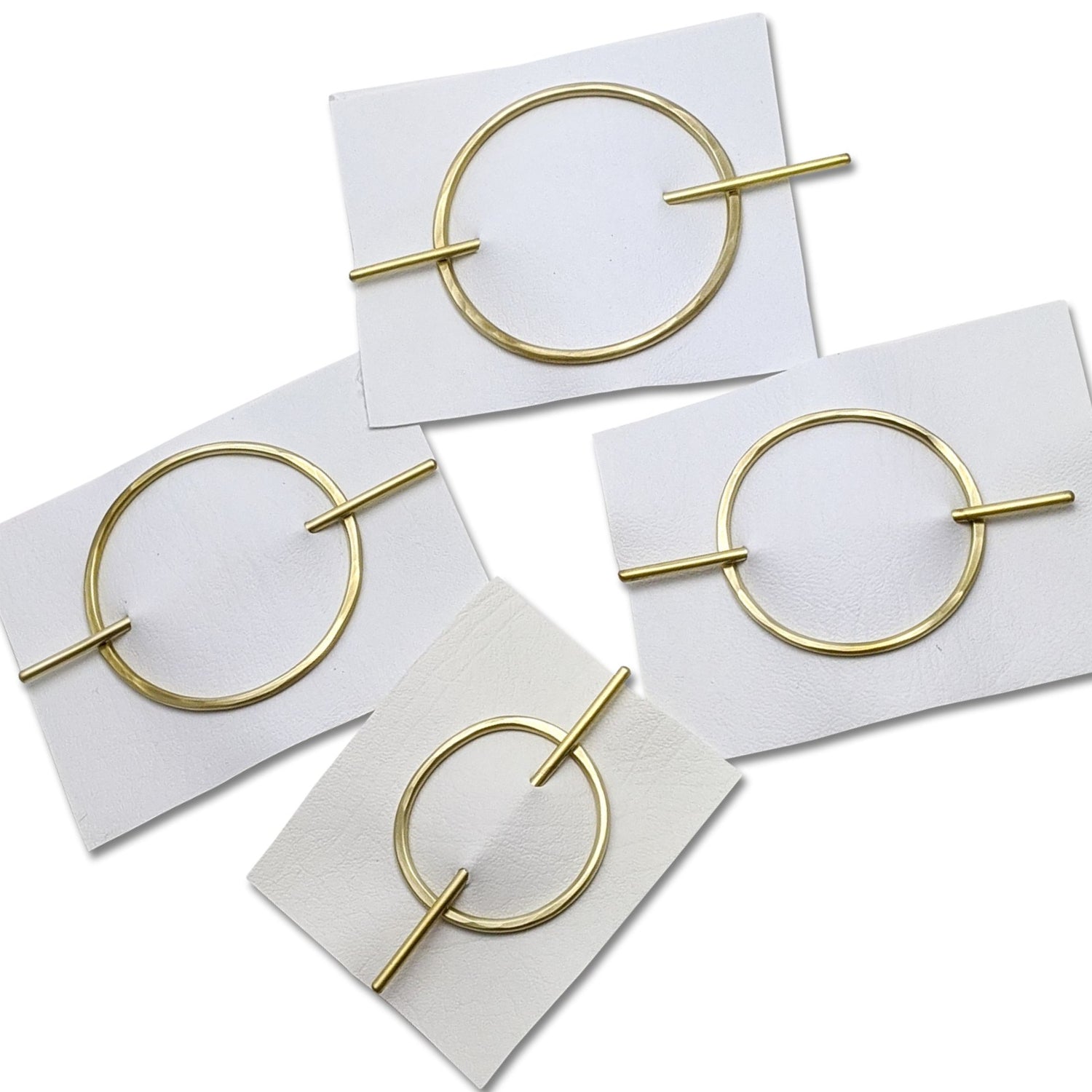 Gold circular hair clips on white cards
