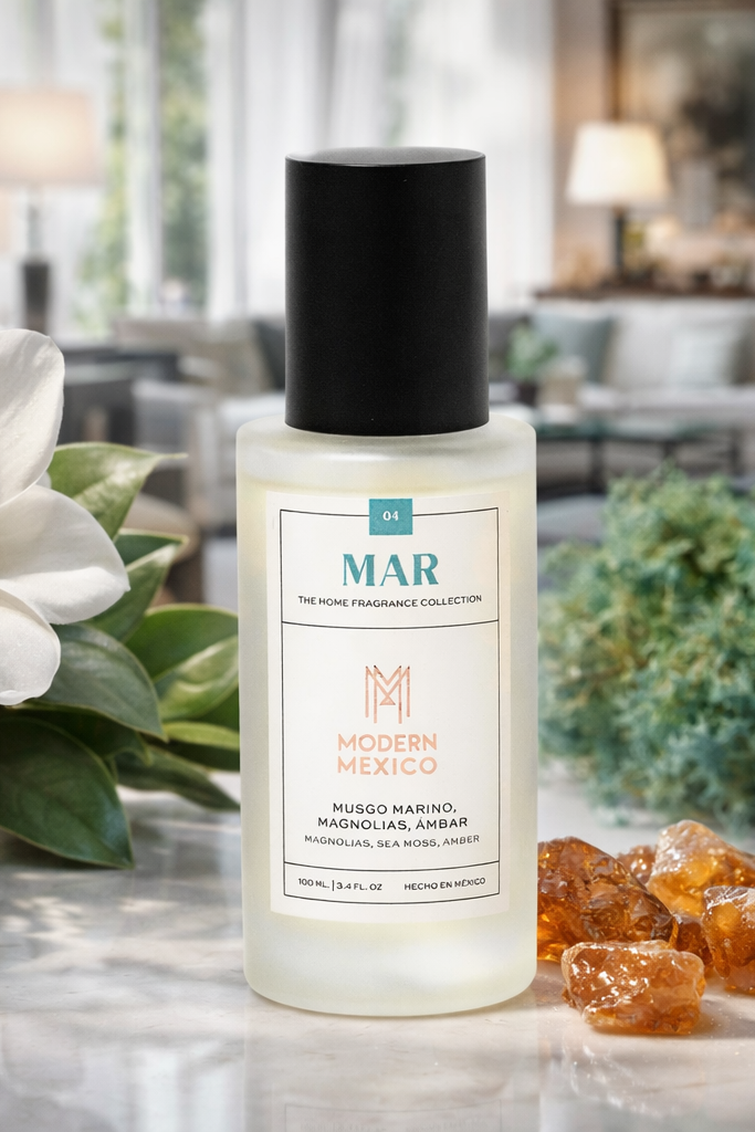 Bottle of MAR Modern Mexico fragrance with decorative elements like flowers, amber, and sea moss on a table