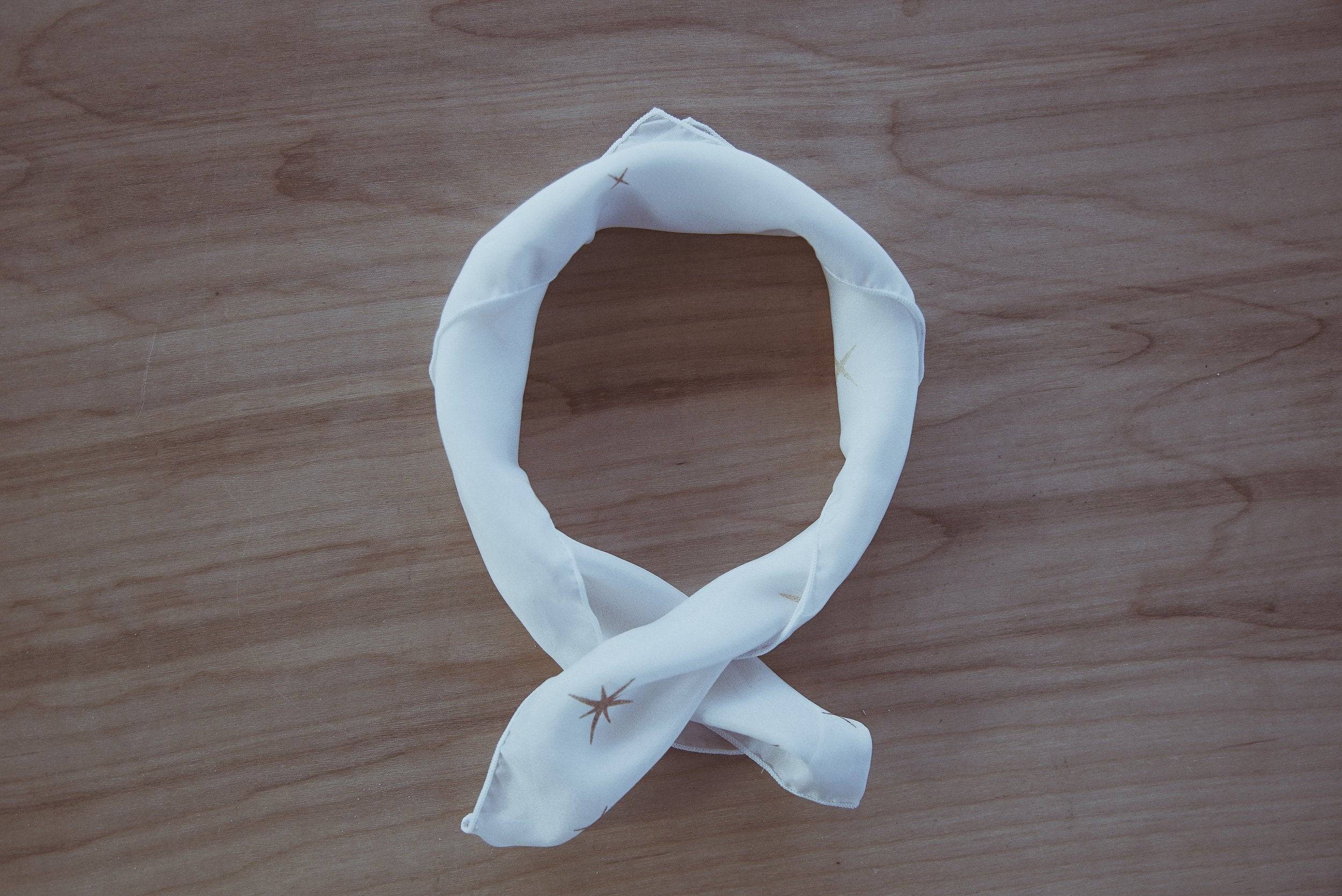 White bandana with a spider on a wooden surface