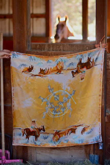 Fabric with horse and nature design hanging in a rustic setting