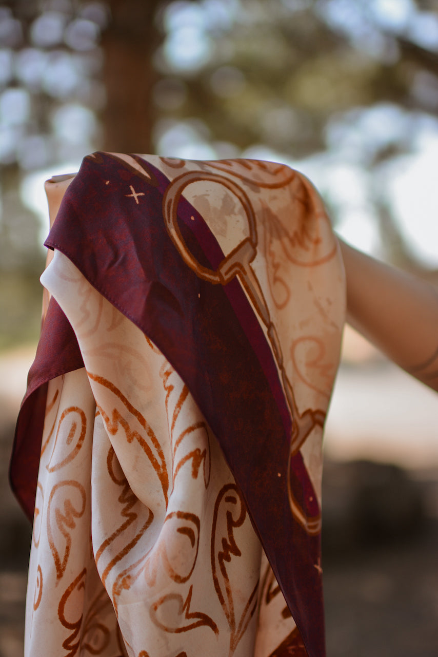 Person holding a patterned fabric with a blurred natural background