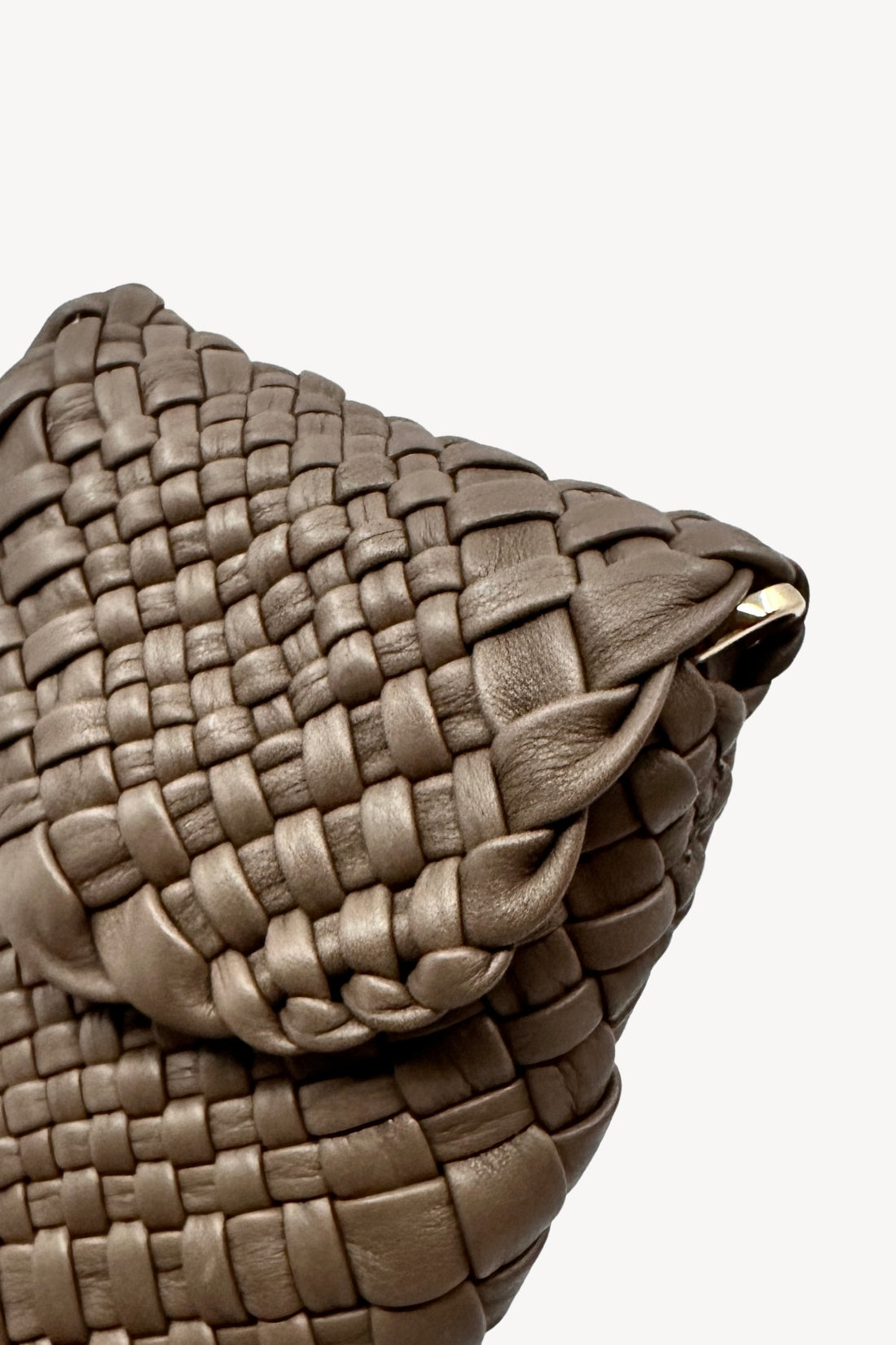 Close-up of a woven beige handbag on a white background
