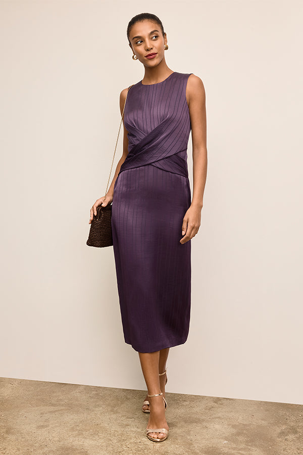 Woman wearing a purple dress against a beige background | Exclude | Grid