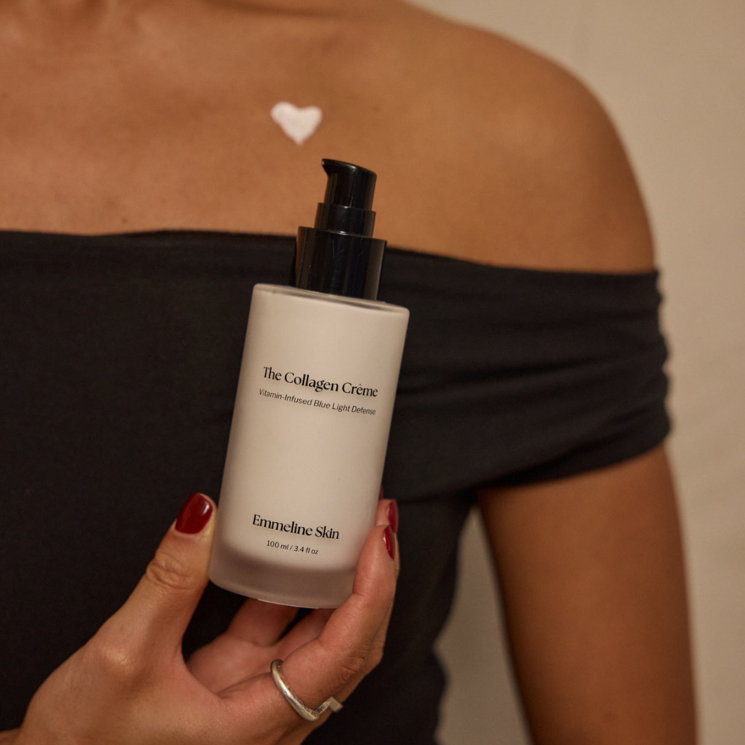 Person holding a bottle of 'The Collagen Creme' by Emmeline Skin against a neutral background