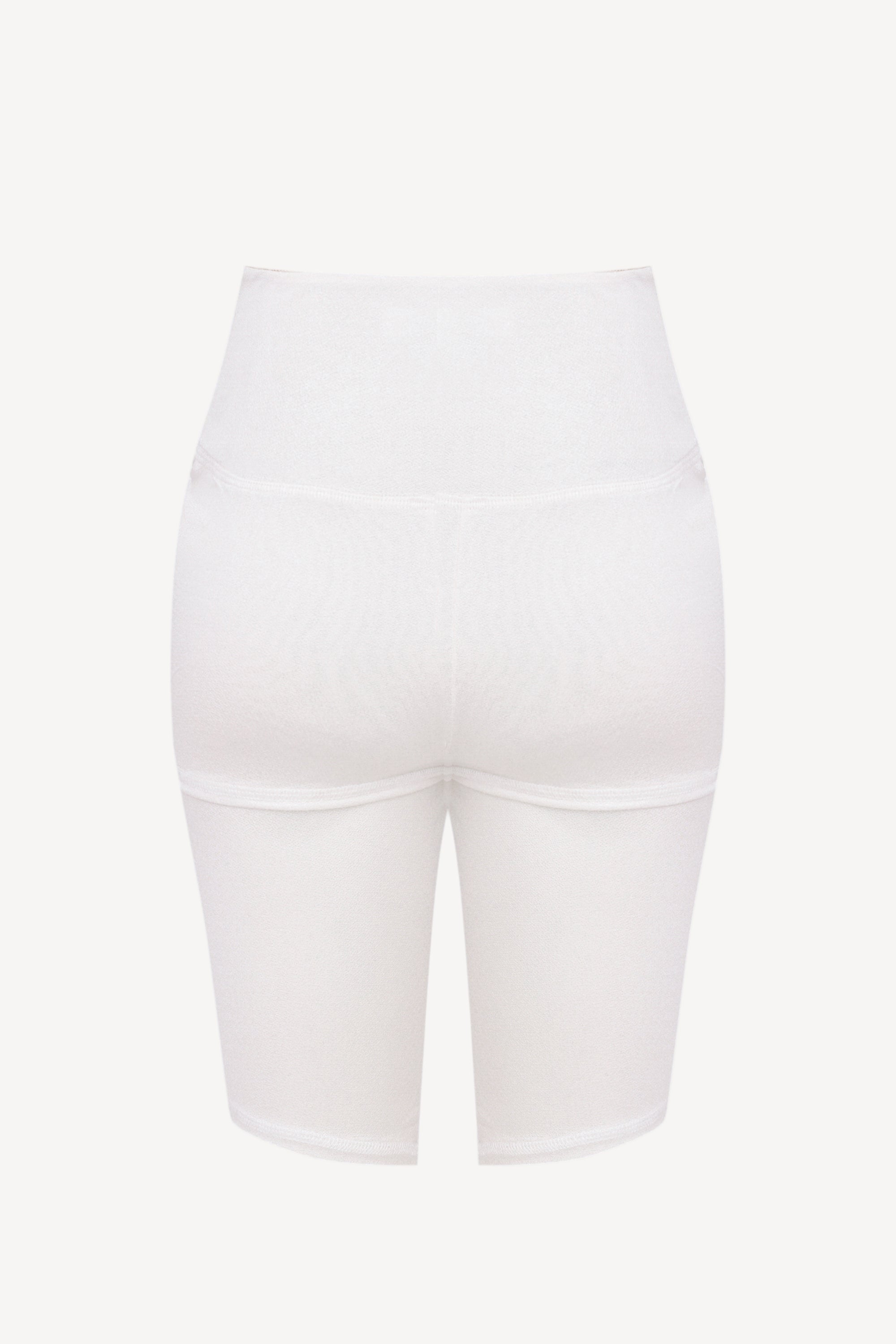 White high-waisted bike shorts on a light beige background