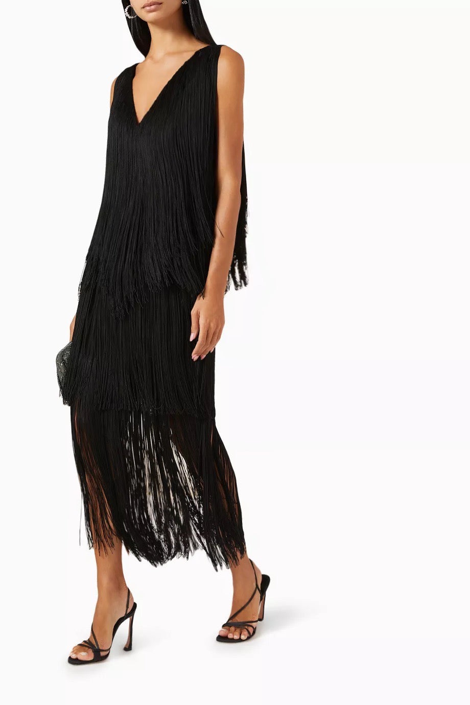 Black fringe dress worn by a model on a white background