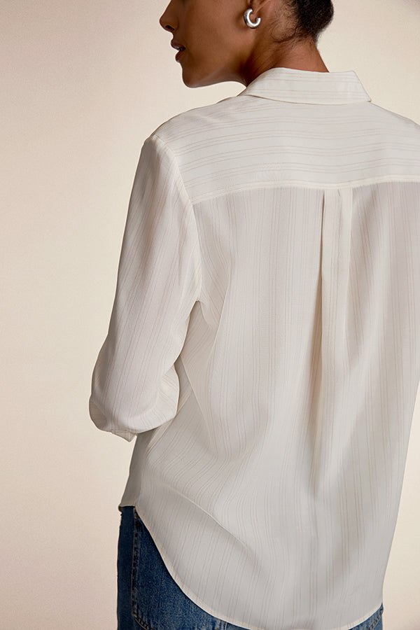 Person wearing a light-colored button-up shirt with a neutral background | Exclude