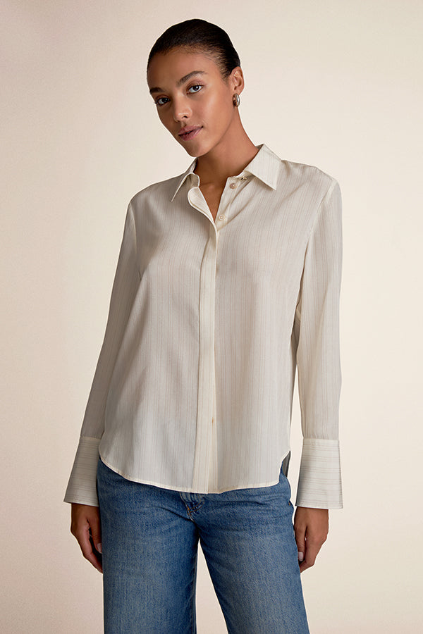 Woman wearing a light-colored shirt and blue jeans against a beige background | Exclude | Grid