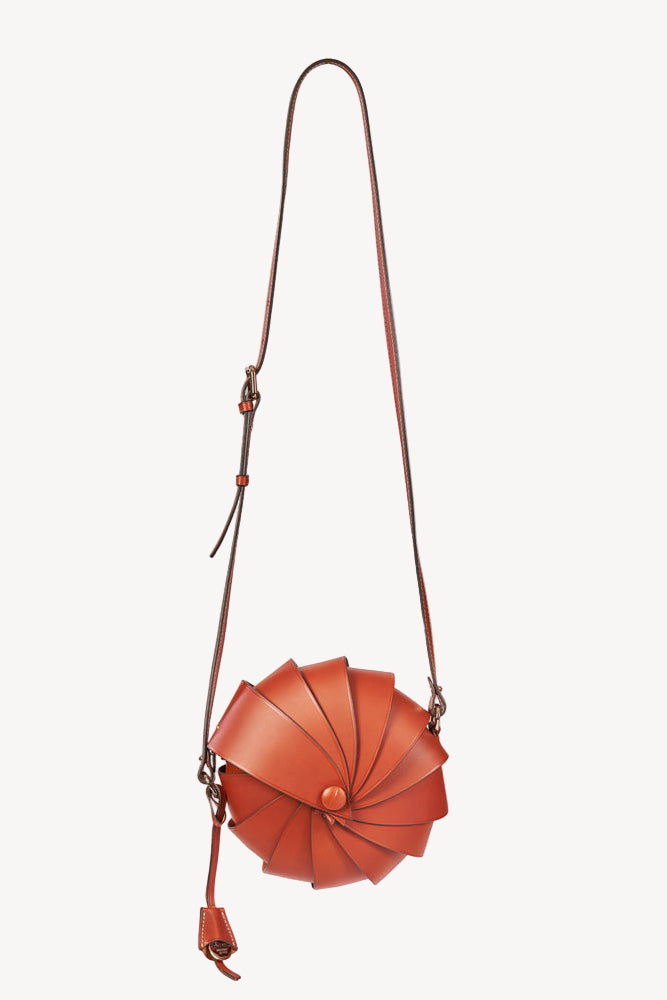 Brown leather handbag with a strap on a white background