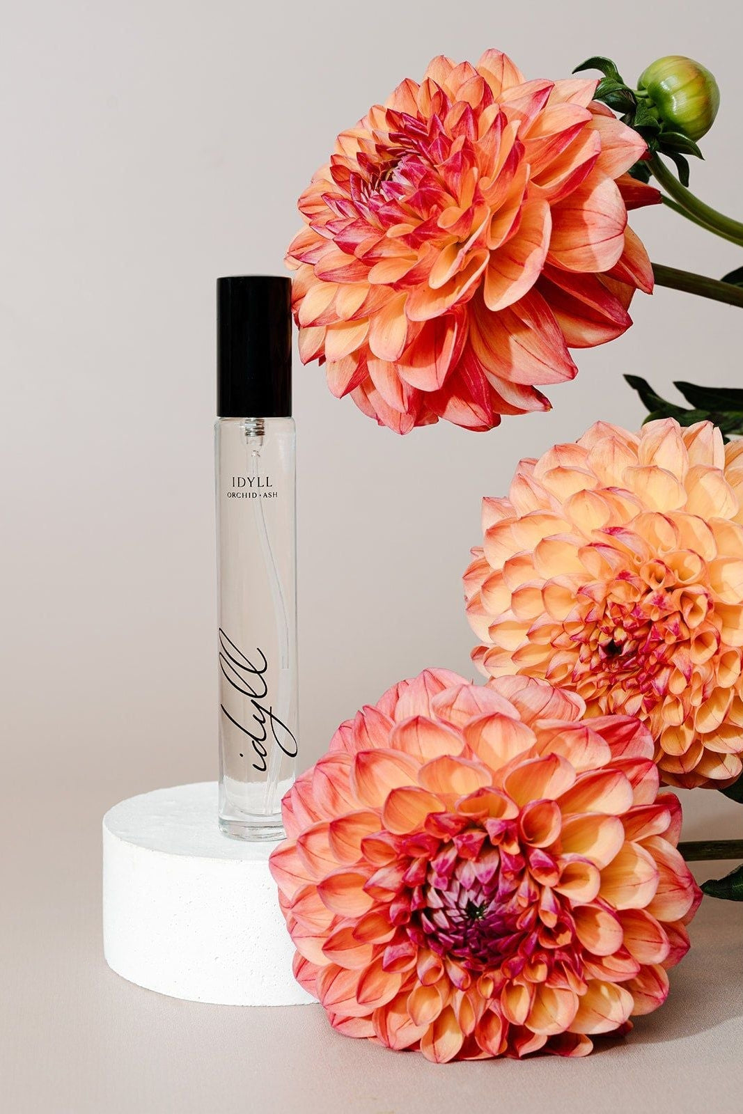 Perfume bottle with orange flowers on a light background