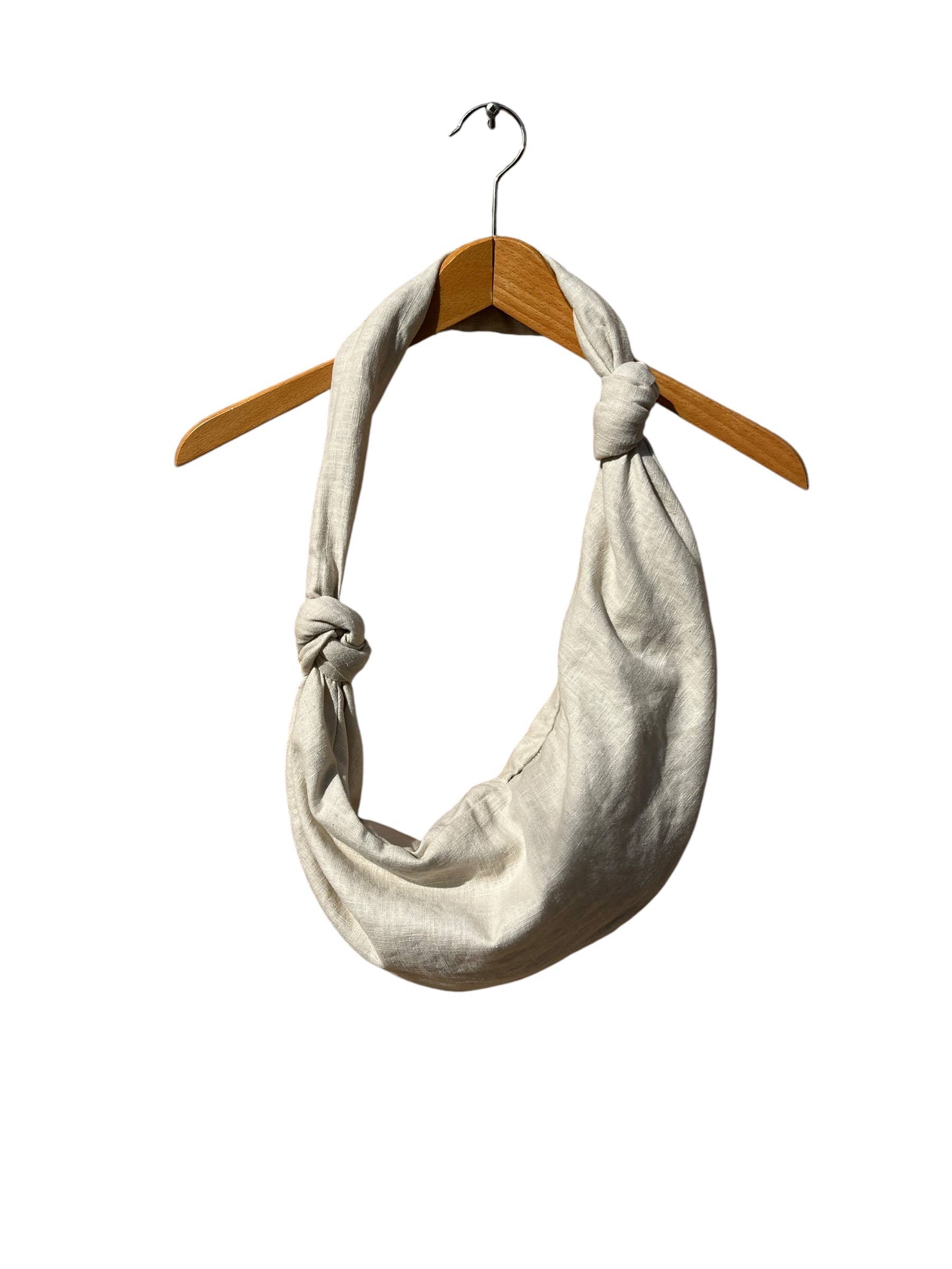 Beige knotted scarf on a wooden hanger against a white background