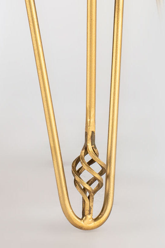 Gold hair clip with intricate design on a light gray background