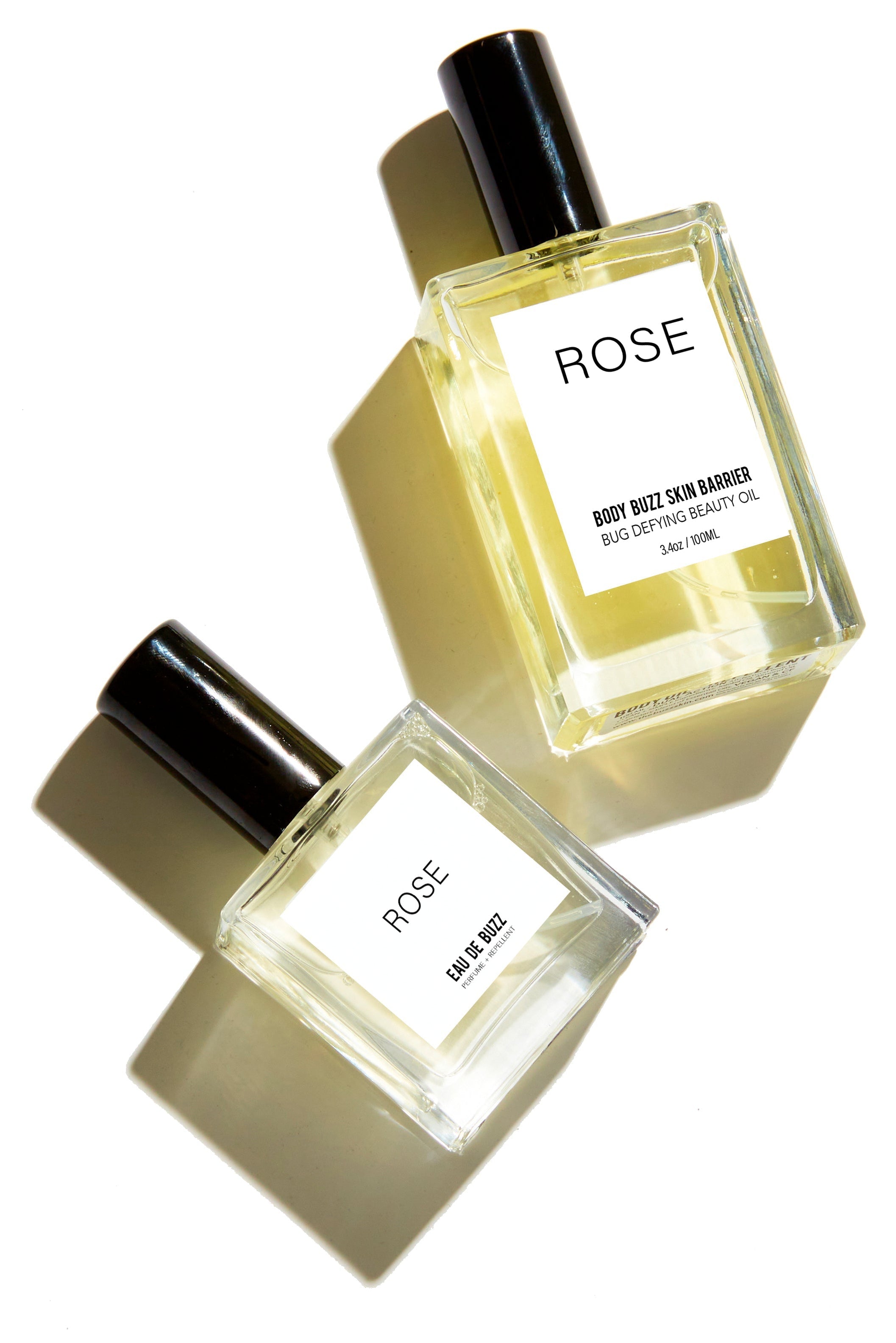 Two bottles of 'Rose' body oil on a white background