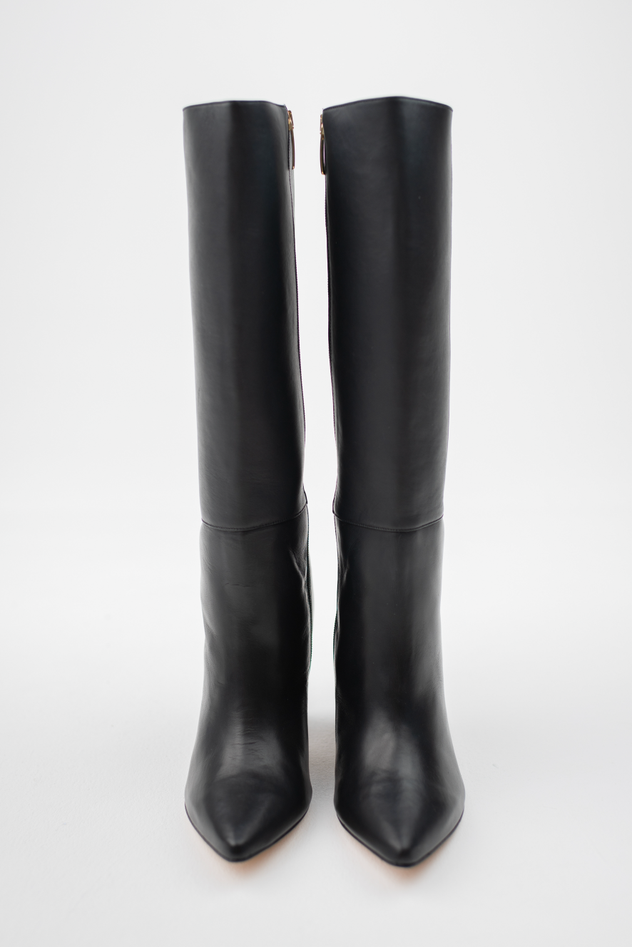 A pair of black leather knee-high boots with pointed toes and high stiletto heels, shown from the front against a plain white background.